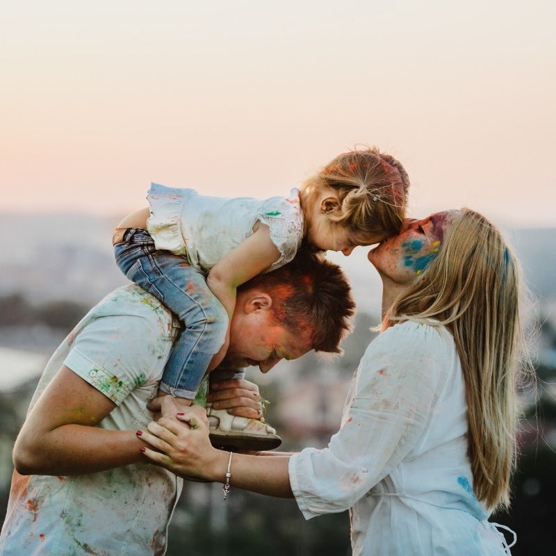 family white shirts covered with different paints stands outside evening